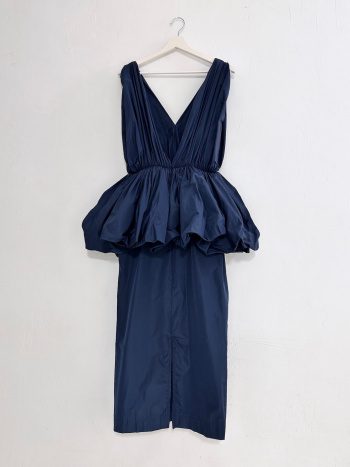 vista trasera en percha del vestido peplum ginebra en azul marino – dearroyo studio