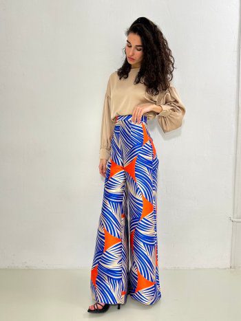 delantero en modelo del pantalón NAGANO con estampado azul, naranja y crudo, combinado con blusa beige oregon. Talle alto con pernera extra ancha – dearroyo studio