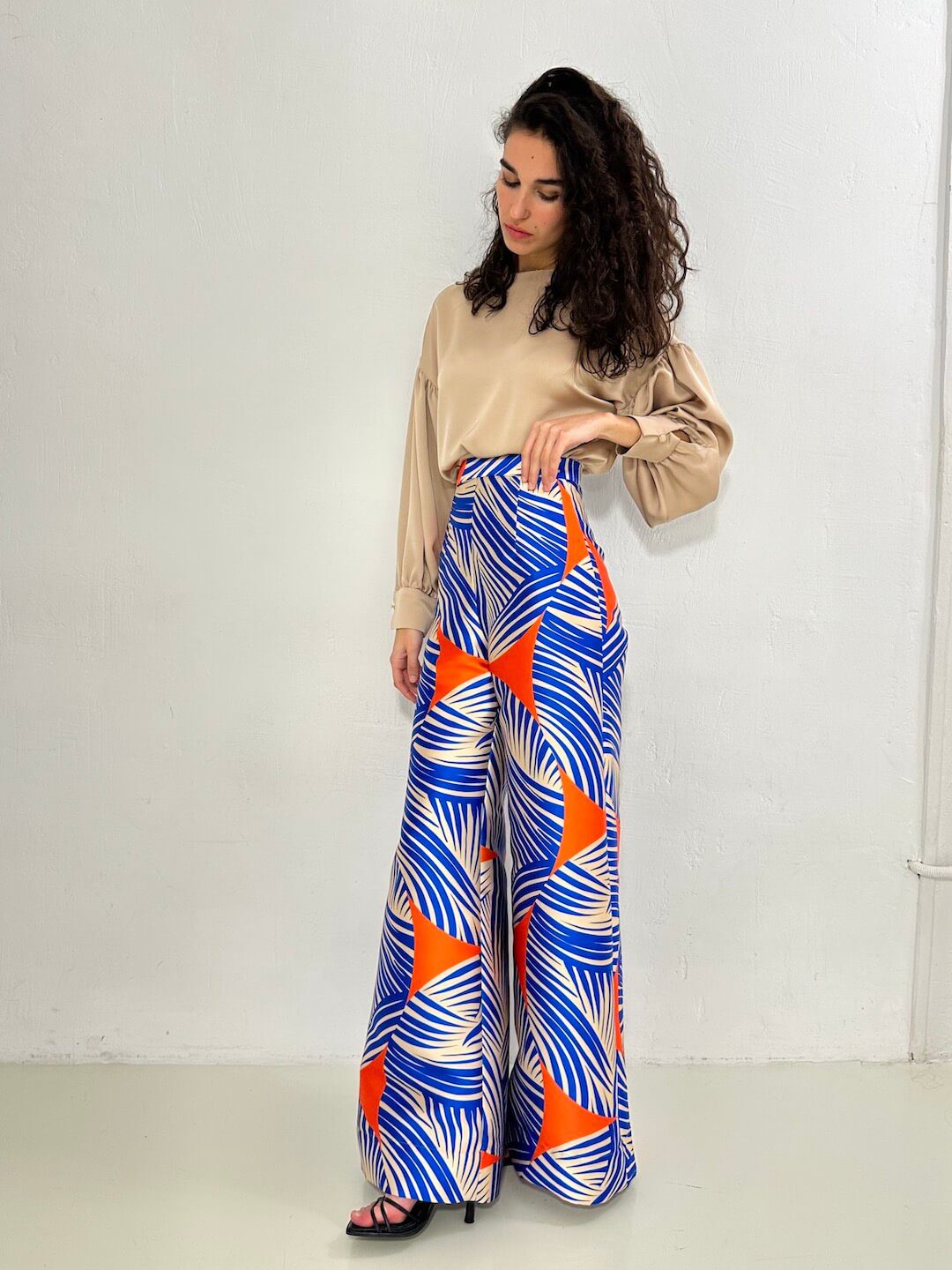 delantero en modelo del pantalón NAGANO con estampado azul, naranja y crudo, combinado con blusa beige oregon. Talle alto con pernera extra ancha – dearroyo studio