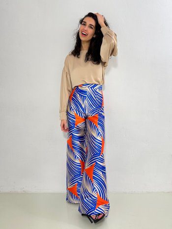 delantero en modelo de pantalón NAGANO con estampado azul, naranja y crudo, combinado con blusa beige. Talle alto con pernera extra ancha – dearroyo studio